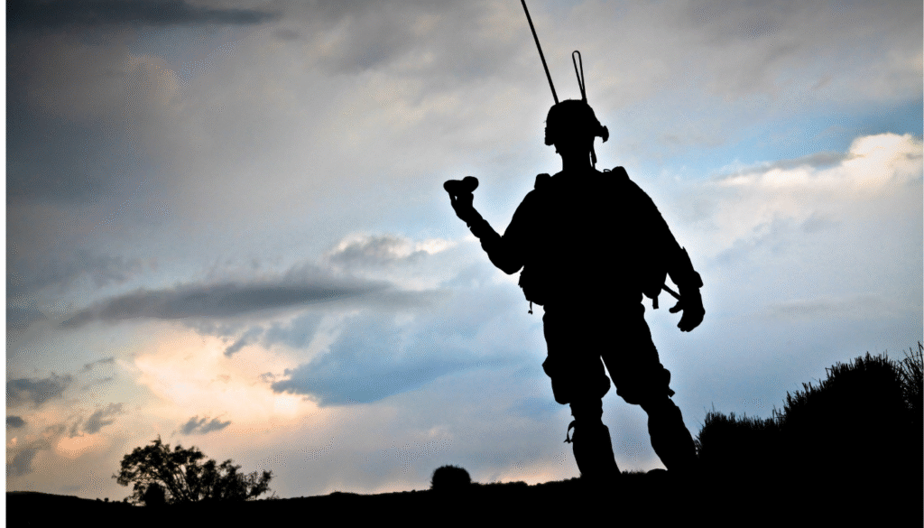 Silhouette d'un militaire avec équipement de parachutisme contre un ciel nuageux, symbolisant engagement et préparation.