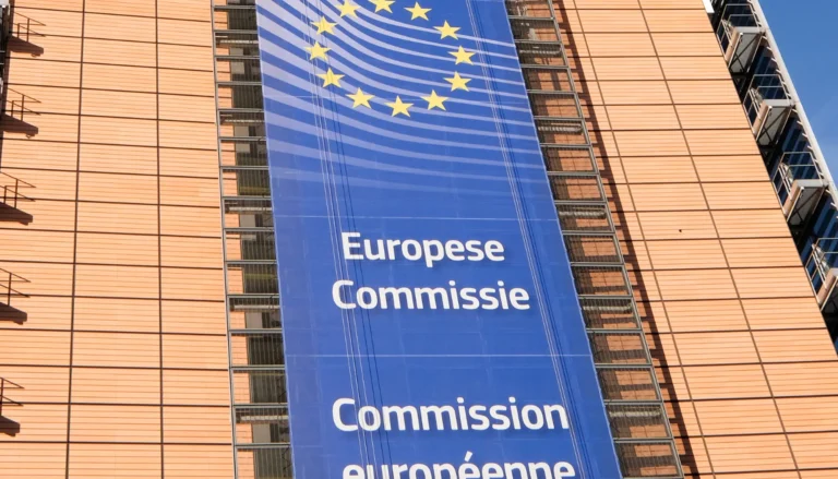 Bannière de la Commission européenne sur bâtiment moderne.