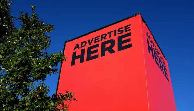 Grand panneau rouge avec le texte "Advertise Here" en noir, illustrant la publicité et la communication visuelle dans le contexte juridique et déontologique.