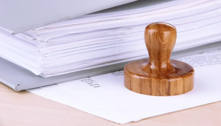 Sceau en bois sur documents juridiques liés à la propriété intellectuelle et aux brevets, illustrant la lutte contre les trolls de brevets.