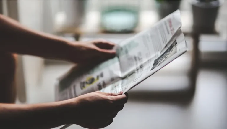 Photo d'une personne tenant un journal ou un document juridique, illustrant le domaine du droit et des services juridiques proposés par Haas Avocats.